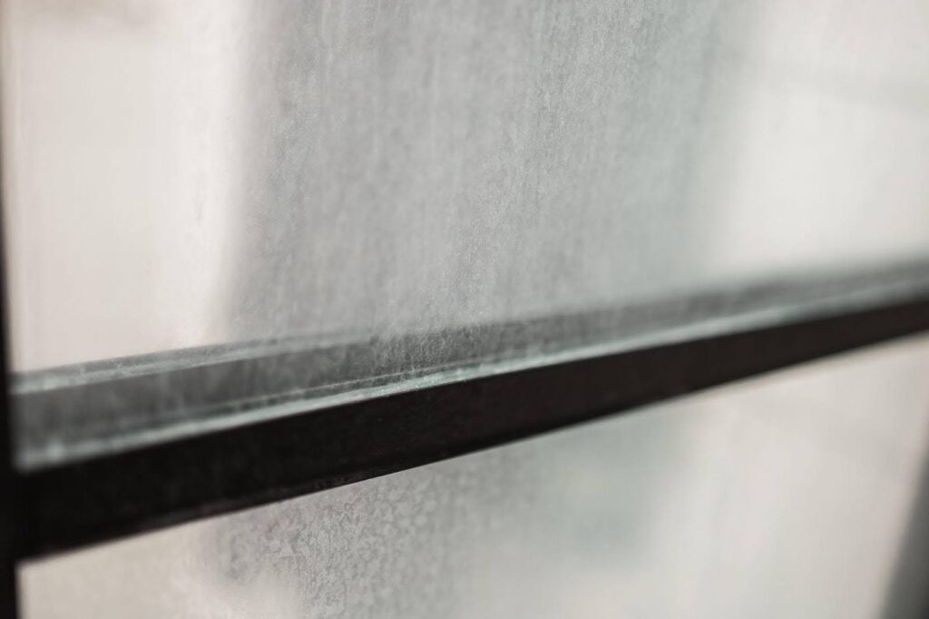 Detailed view of a window featuring a sleek black frame emphasizing its modern design