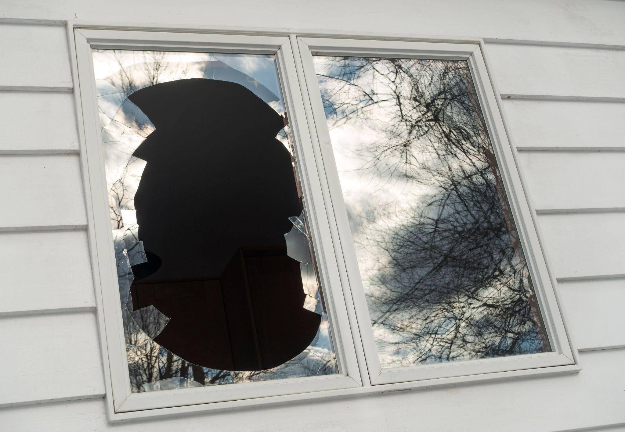 Shattered double pane house window with a large jagged hole