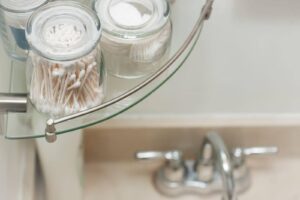A glass shelf displaying various toothbrushes and personal care items organized neatly