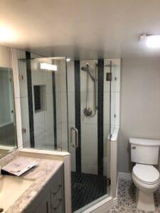 A modern bathroom featuring a shower, toilet, and sink.