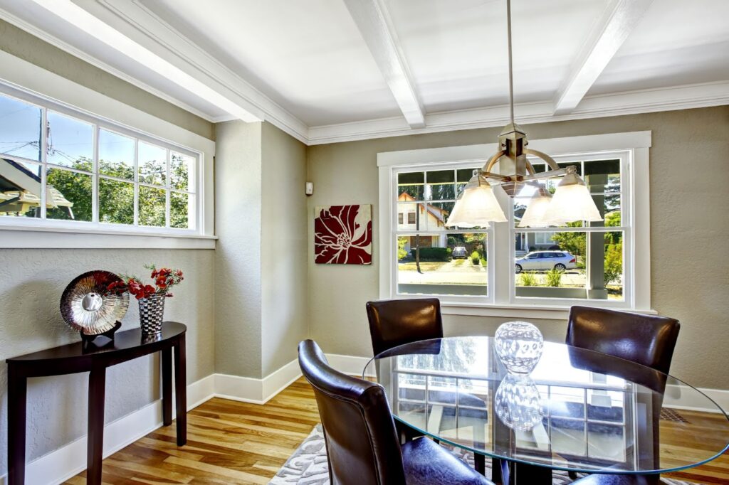Modern dining room with glass table, leather chairs, and large windows.