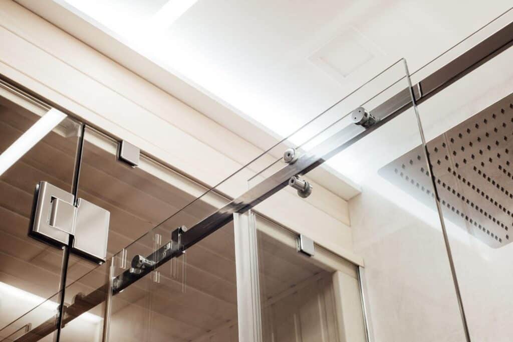 A glass shower door featuring a sleek metal frame showcasing a modern bathroom design