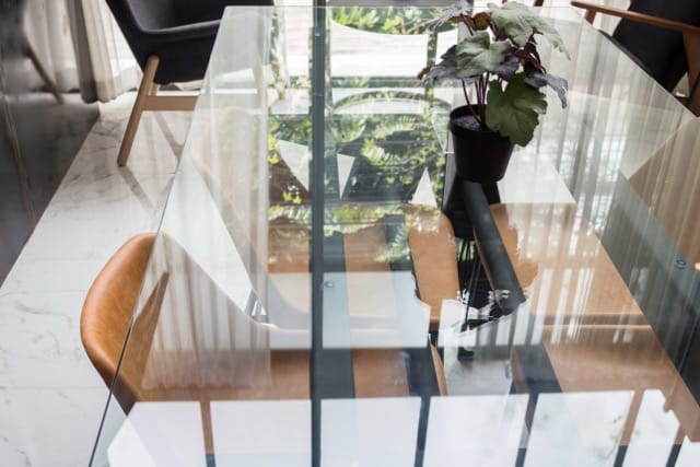 A glass table with matching chairs in a stylish modern home, highlighting a minimalist dining area.
