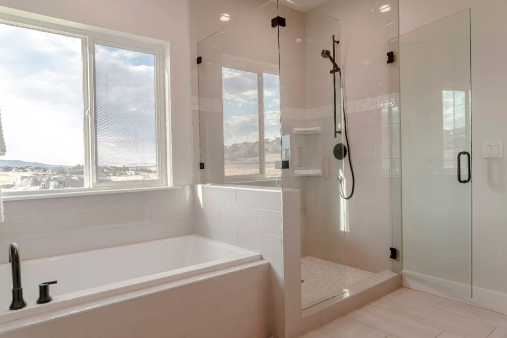 A modern bathroom featuring a glass shower door alongside a stylish bathtub