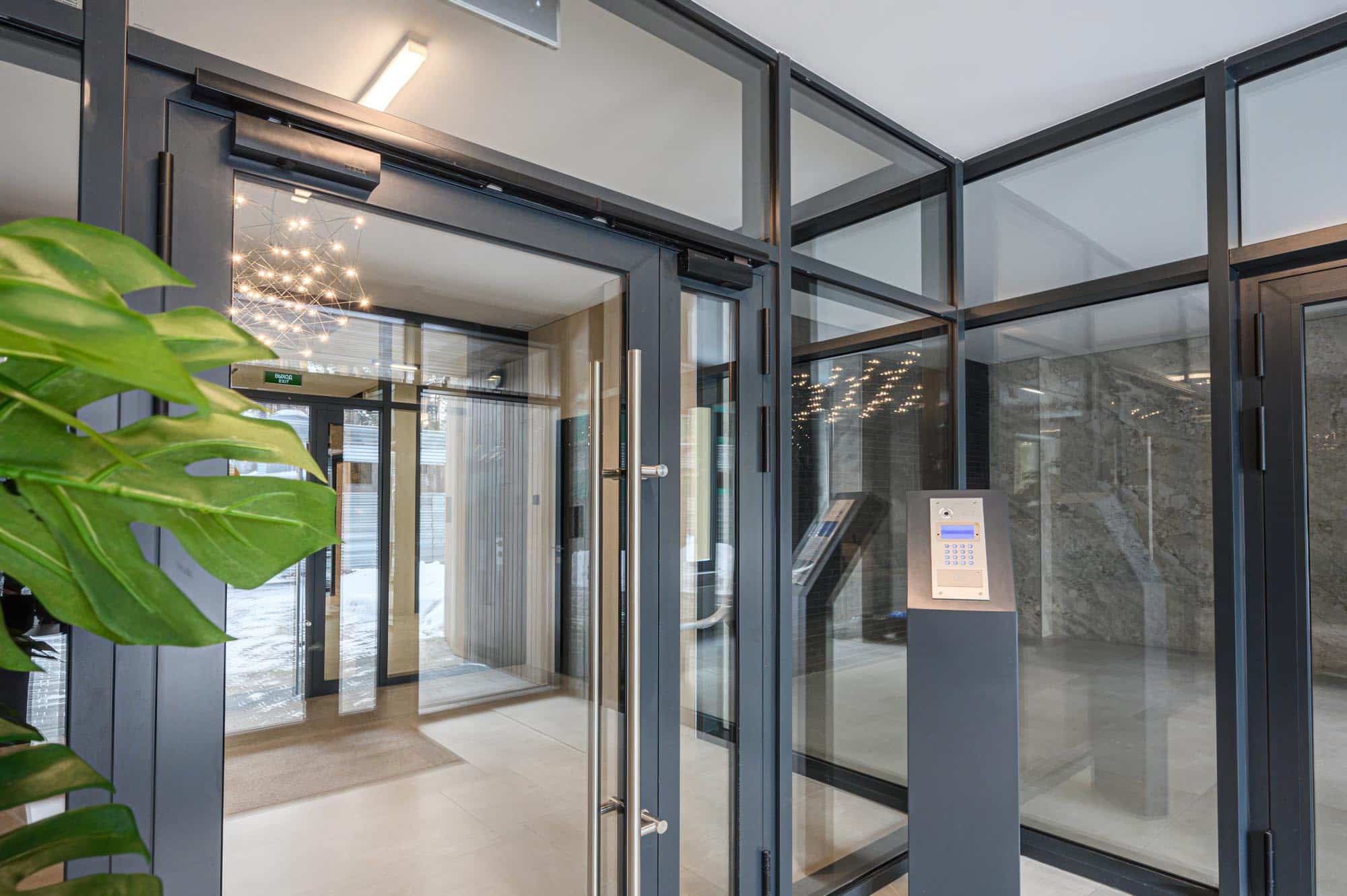 Modern entrance with glass doors, access control panel, sleek me