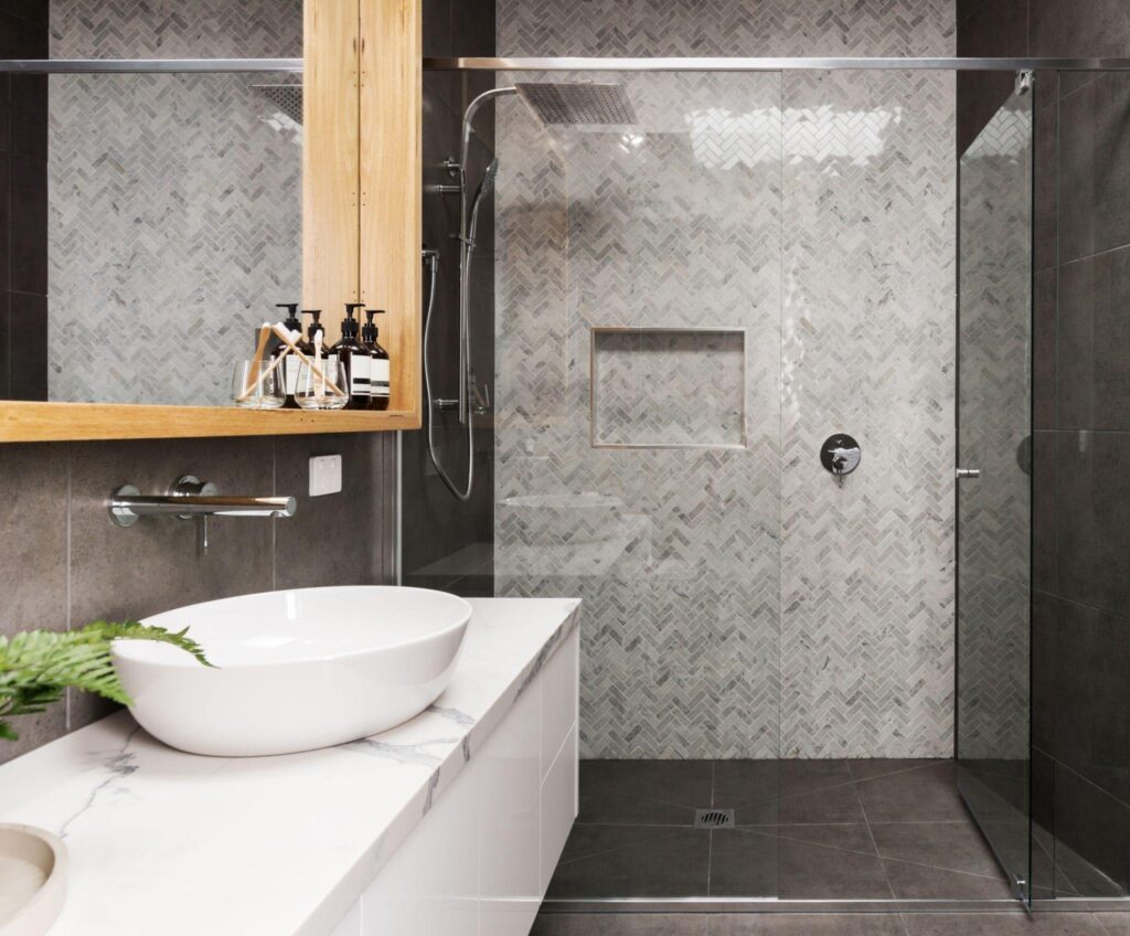 A modern bathroom featuring a glass shower enclosure and a sleek sink with contemporary fixtures